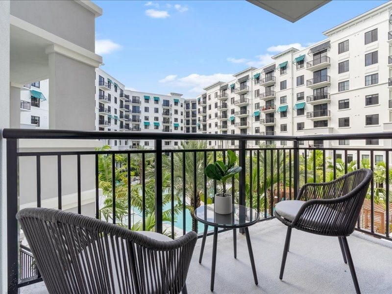 a balcony with two chairs and a table on a balcony