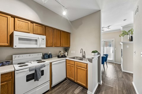 A kitchen with wooden cabinets and white appliances.