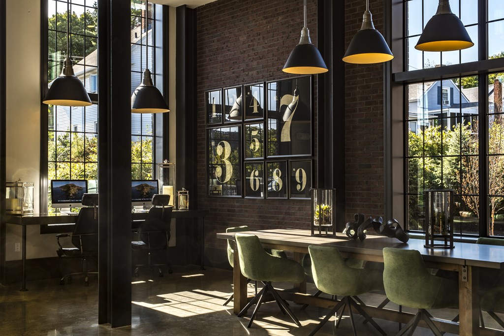 A room with a table and chairs and a clock on the wall.
