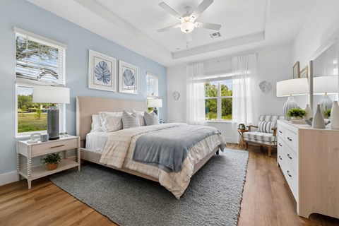 A bedroom with a large bed and a ceiling fan.