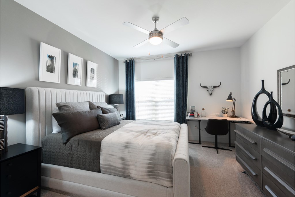 a bedroom with a large bed and a ceiling fan