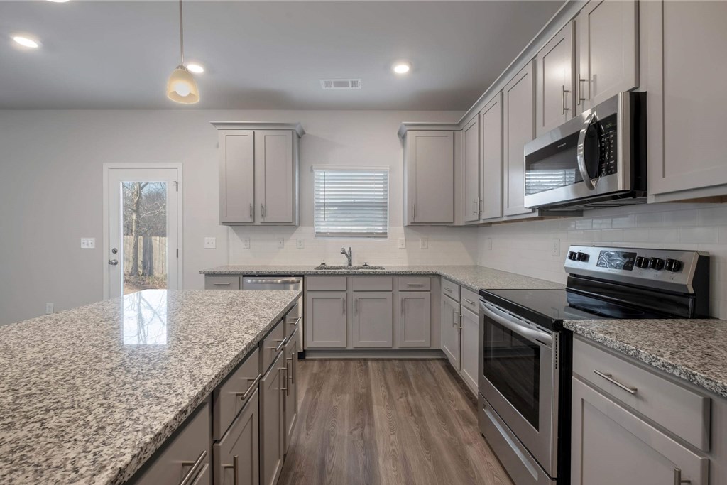 a kitchen with granite counter tops and white cabinets