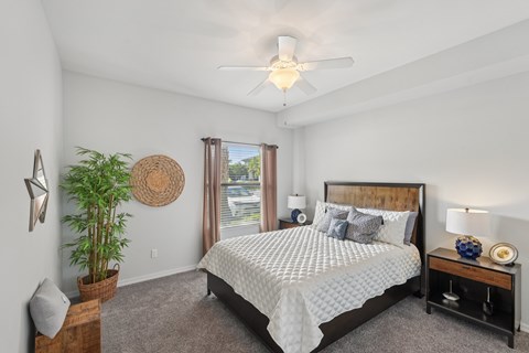 A bedroom with a large bed and a ceiling fan.