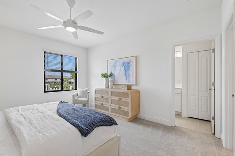 A bedroom with a white bed and a blue blanket.