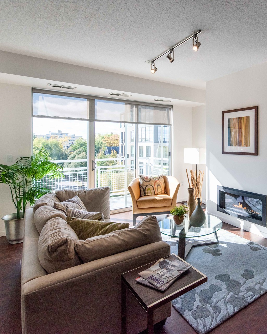 Living room with a large couch facing a coffee table and fireplace on opposite wall