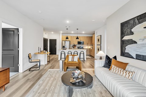 A modern living room with a white couch and a coffee table in the center.