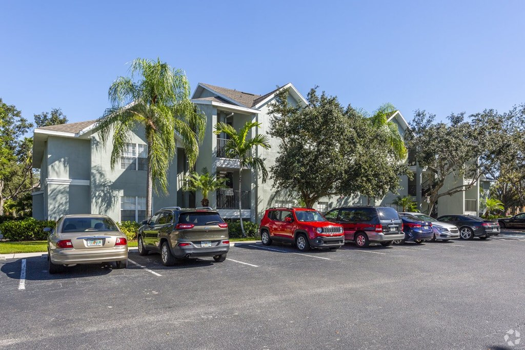 a parking lot with cars parked in front of a building