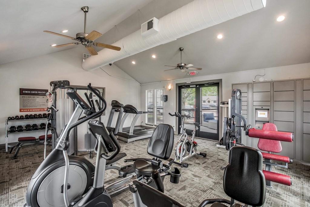 a home gym with exercise equipment and ceiling fans