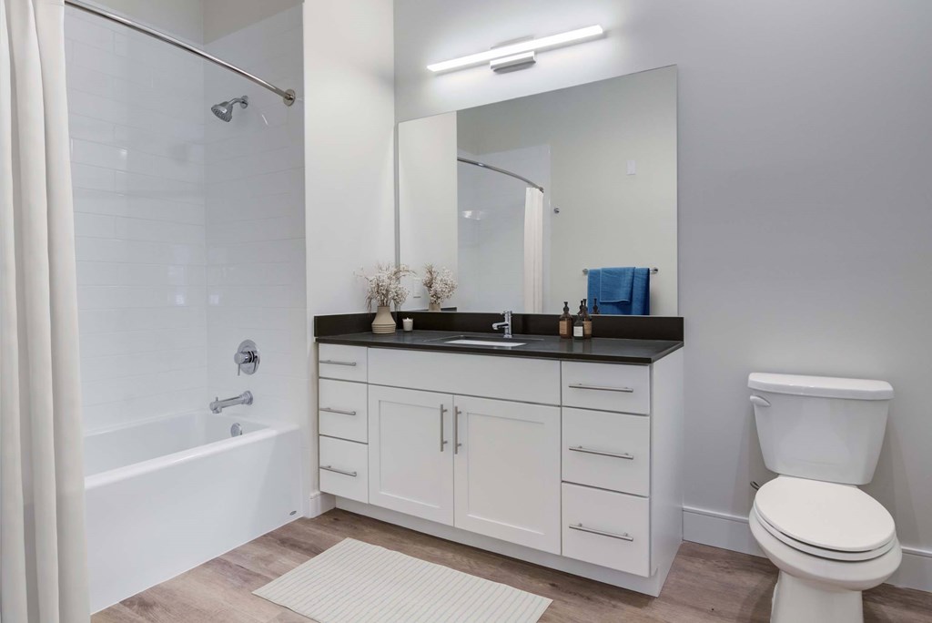A white bathroom with a toilet, sink, and bathtub.