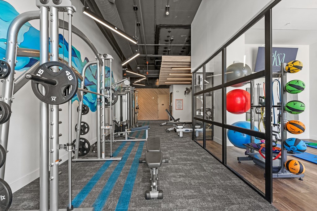 A gym with a variety of equipment including weights and exercise balls.