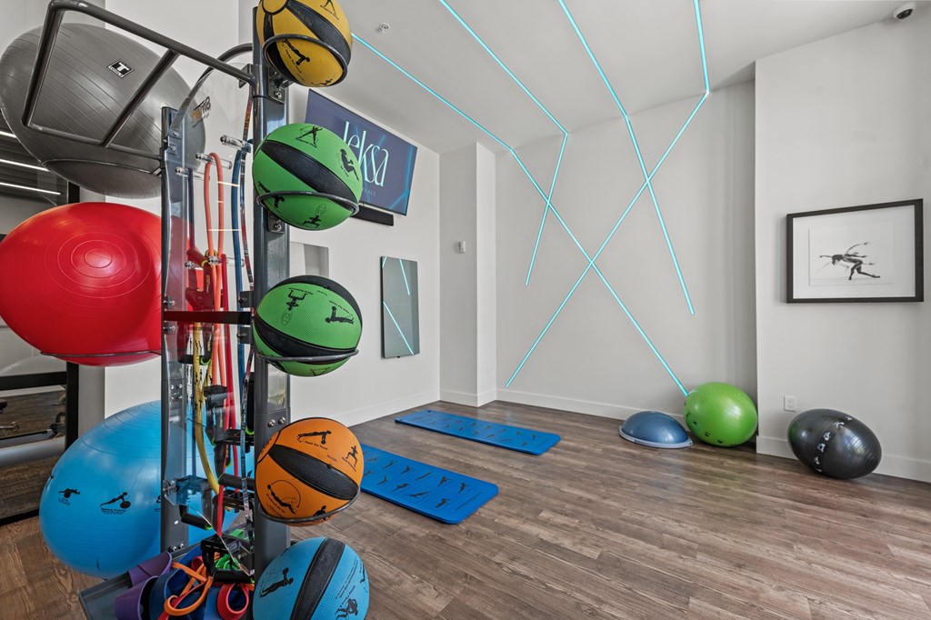 A gym with exercise balls and a rack of resistance bands.