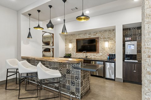 A kitchen with a bar area and a stone wall.