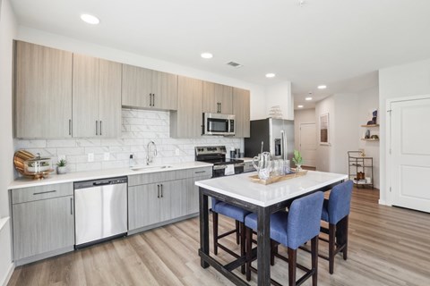 A modern kitchen with a dining table and chairs.