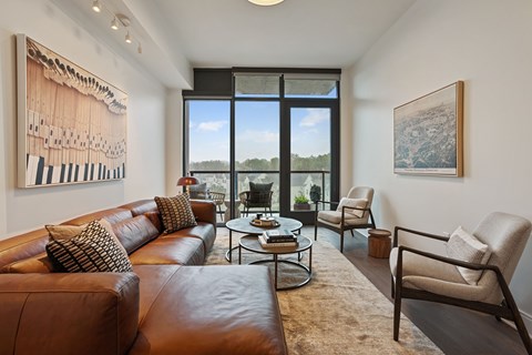 A living room with a brown leather couch and a coffee table.