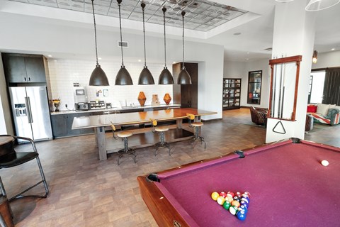A pool table with a red cloth and a white cue ball in the middle.