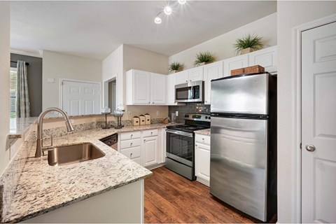 a kitchen with stainless steel appliances and granite counter tops