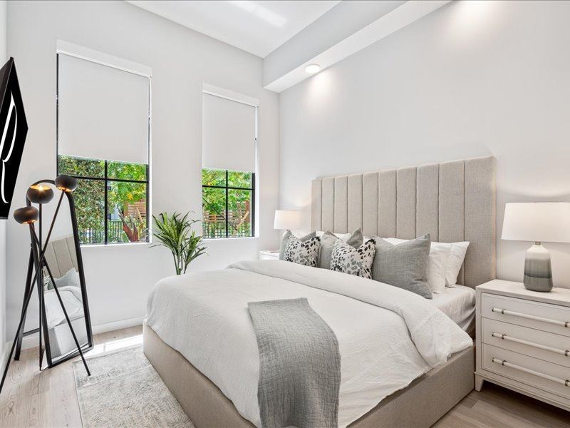 a bedroom with a bed and two windows