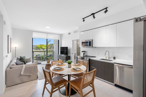 A modern kitchen with a dining table set for two.