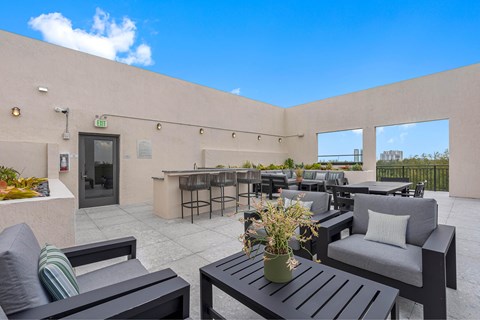 A patio with black furniture and a table with a vase on it.