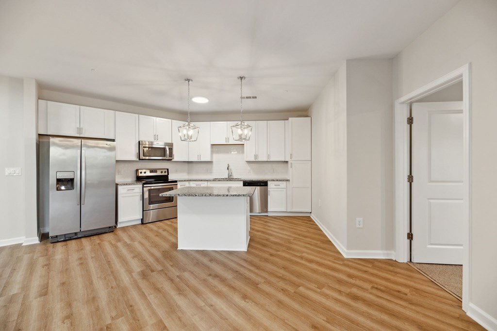 a renovated kitchen with white cabinets and stainless steel appliances