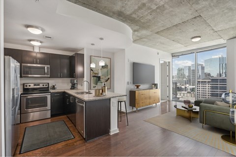 A modern kitchen with dark wood cabinets and stainless steel appliances.