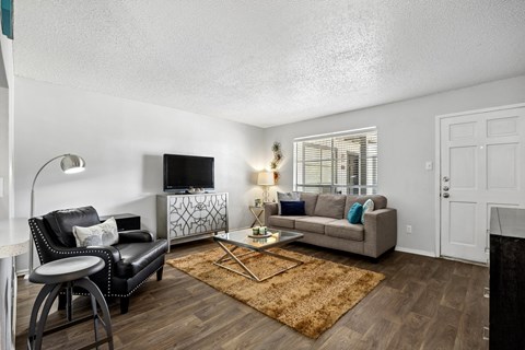 A living room with a black leather chair and a white sofa.