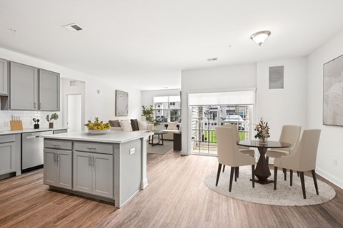 A kitchen with a dining table and chairs in the middle of the room.