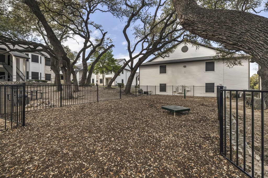 a fenced in yard with trees and a picnic table