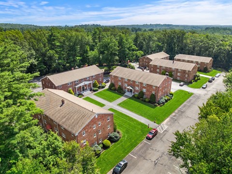 A large red brick building surrounded by trees.