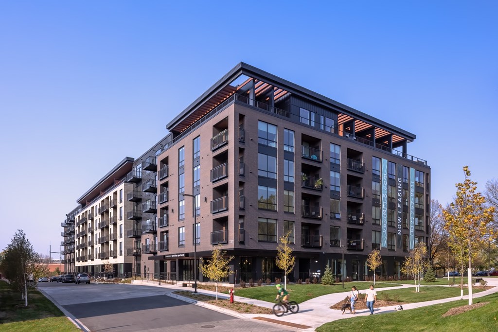 a rendering of a large apartment building on a city street