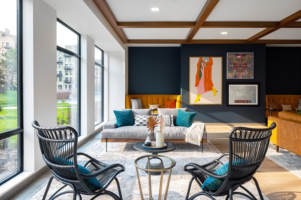 a living room with blue chairs and a couch and a large window