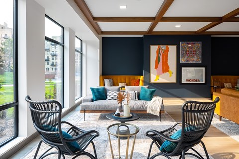 a living room with blue chairs and a couch and a large window