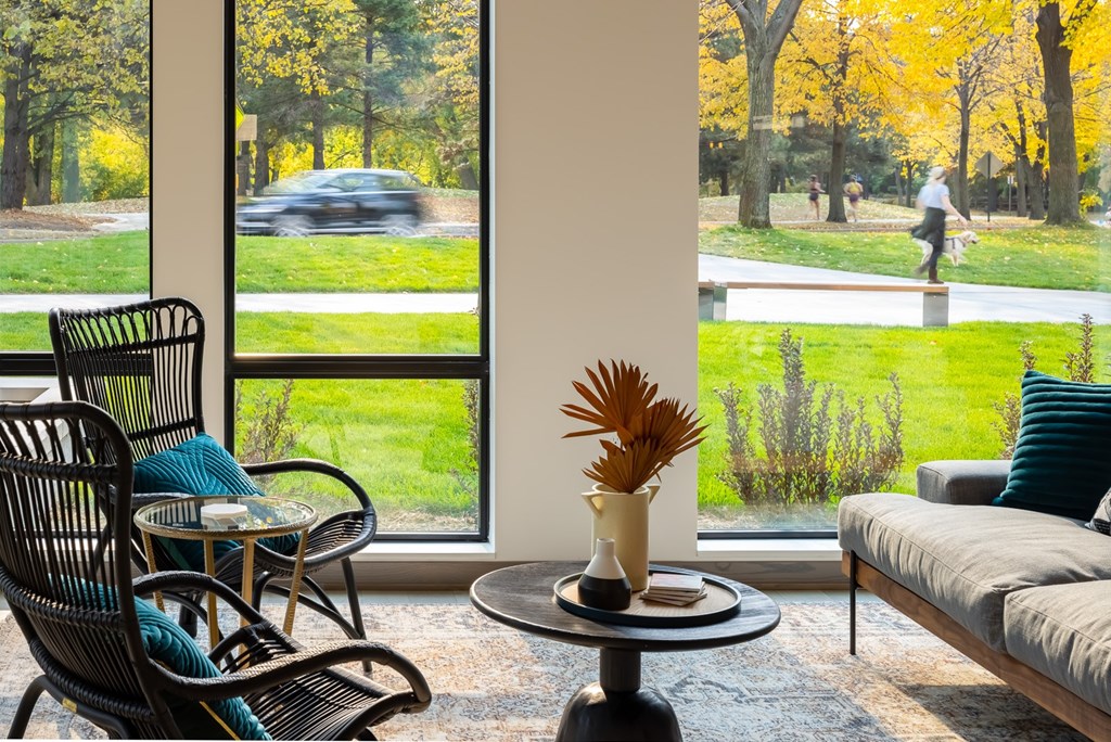 a living room with chairs and a table in front of a window