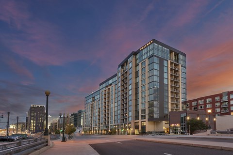 A modern glass building stands tall in the evening sky.