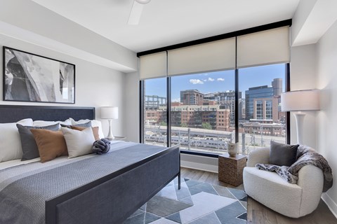 A bedroom with a large bed and a view of the city.