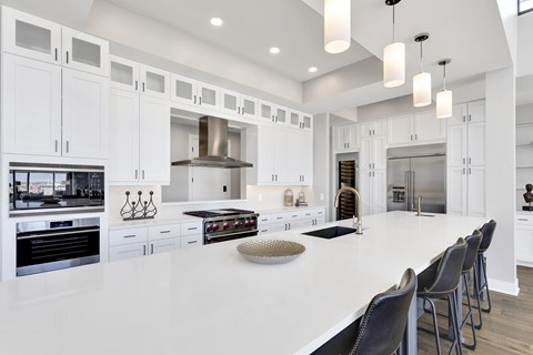 A modern kitchen with white cabinets and a large island.