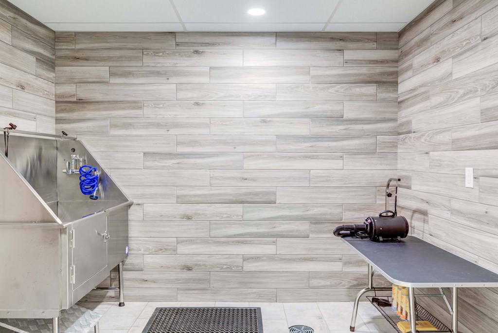 A kitchen with a stainless steel sink and a wooden wall.