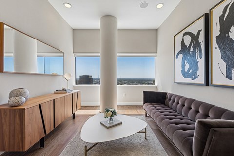 A living room with a brown couch and a white coffee table.
