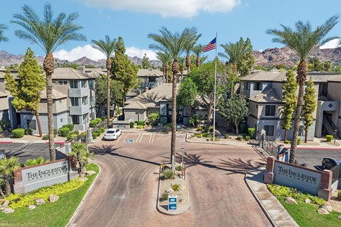 The entrance to a residential complex with a flag flying in the background.