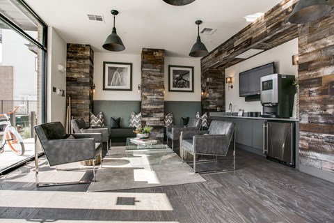 A modern living room with a grey sofa set and a wooden wall.