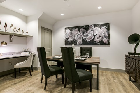 A modern dining room with a large abstract painting on the wall.