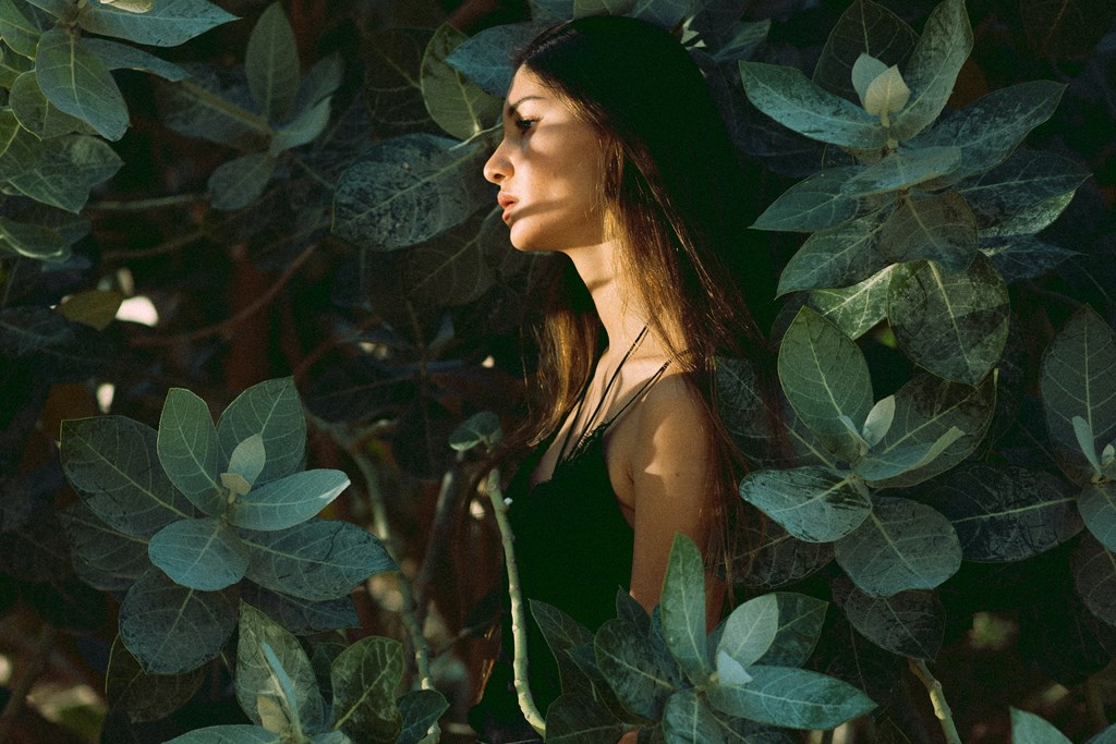 a woman standing in the leaves of a plant