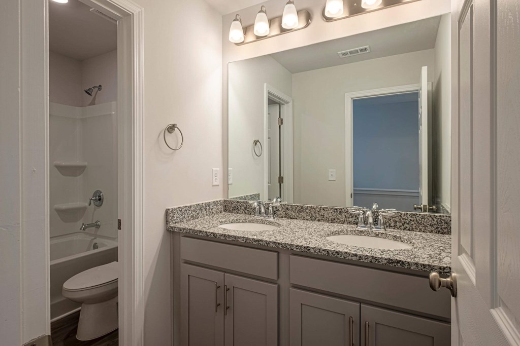 a bathroom with granite counter tops and a large mirror