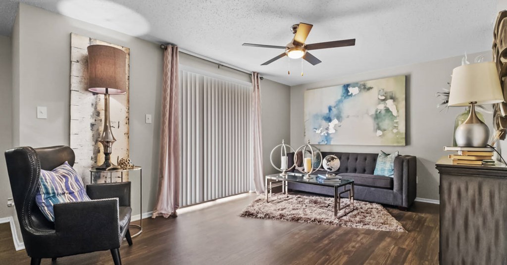 a living room with a ceiling fan and a sliding glass door