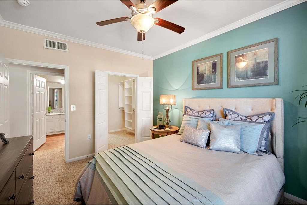 a bedroom with a large bed and a ceiling fan