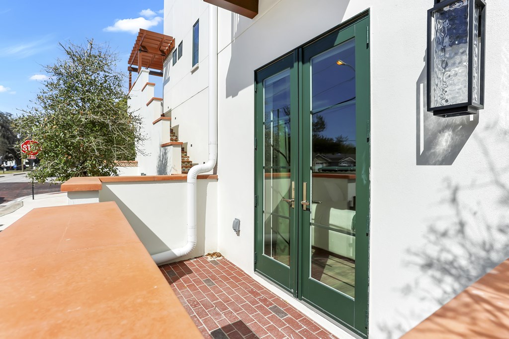 A white building with a green door and a red stop sign in the background.