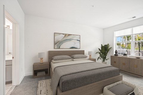 Two Bedroom Garden-Style Apartments in Mt. Laurel Township, NJ - Laurel Green - Bedroom with Wooden Bed Frame, Nightstands with Lamps, Attached Bathroom, and Large Window.