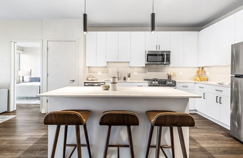 A modern kitchen with white cabinets and a large island.