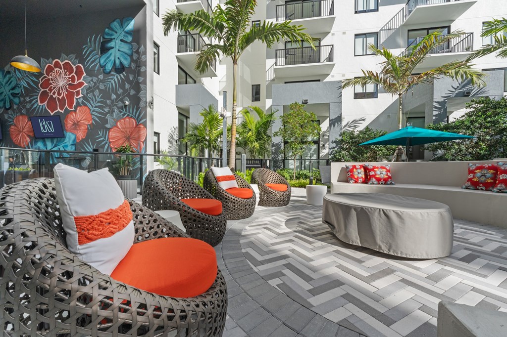 Paseo with a white couch and orange pillows.