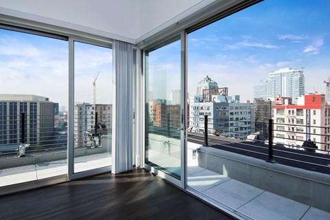 A room with a view of the city through large windows.